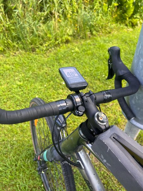 Ein Fahrradlenker mit einem GPS-Gerät auf einem grünen Grasshintergrund.